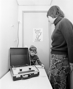 858383 Afbeelding van een gehoortest bij een schoolkind in de wijkpost van de GG & GD (Amazonedreef 43) te Utrecht.